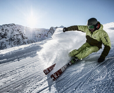 Ein Skifahrer auf einer präparierten Piste mit Sonnenschein in der Silvetta Montafon im Winter