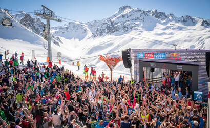 Eine Menschenmenge steht vor der Bühne im Skigebiet, auf welcher DJ Ötzi steht, und singt mit.