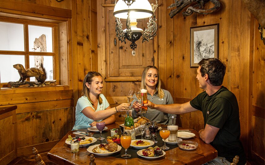 Drei Personen in einer gemütlichen Holzstube beim Bergfrühstück in der Nova Stoba in der Silvretta Montafon. | © Silvretta Montafon - Vanessa Strauch