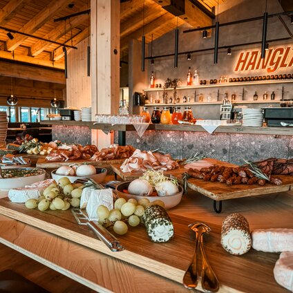 Ein gedecktes Frühstücksbuffet mit Käse, Wurst und Säften. | © Silvretta Montafon - Vanessa Strauch
