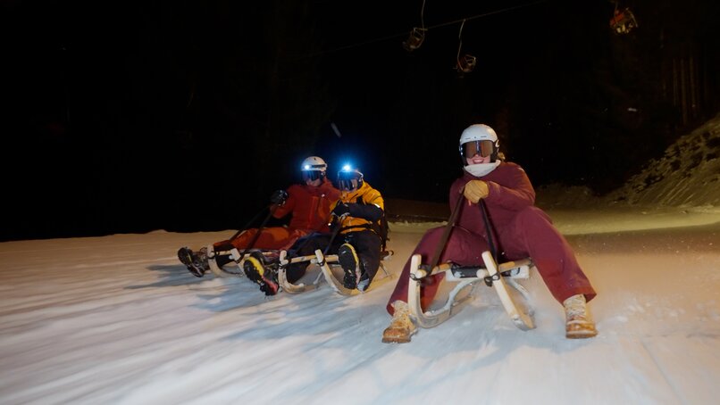 Drei Personen auf einem Rodel bei Nacht. | © Silvretta Montafon - Niklas Kirchler