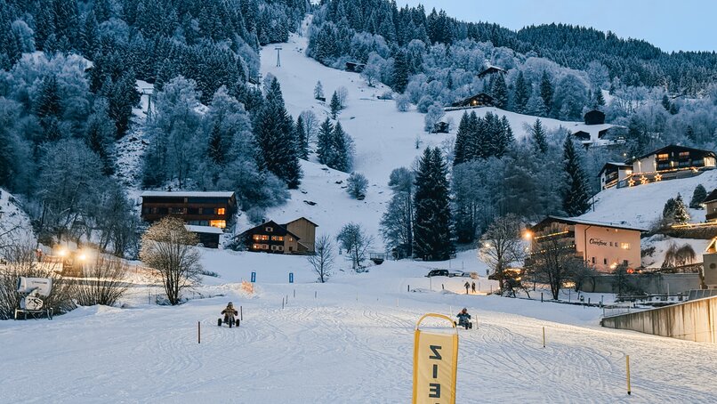 Zwei Personen in Skikleidung bei der Zieleinfahrt der Mountaincarts-Strecke. | © Silvretta Montafon - Vanessa Strauch