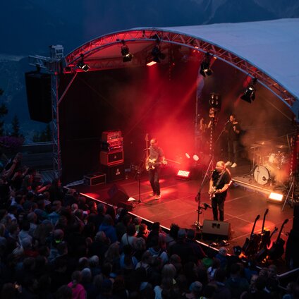 Ein Konzert beim Sonnenuntergang mit bunter Beleuchtung und großem Publikum | © Silvretta Montafon- Frederike Weber