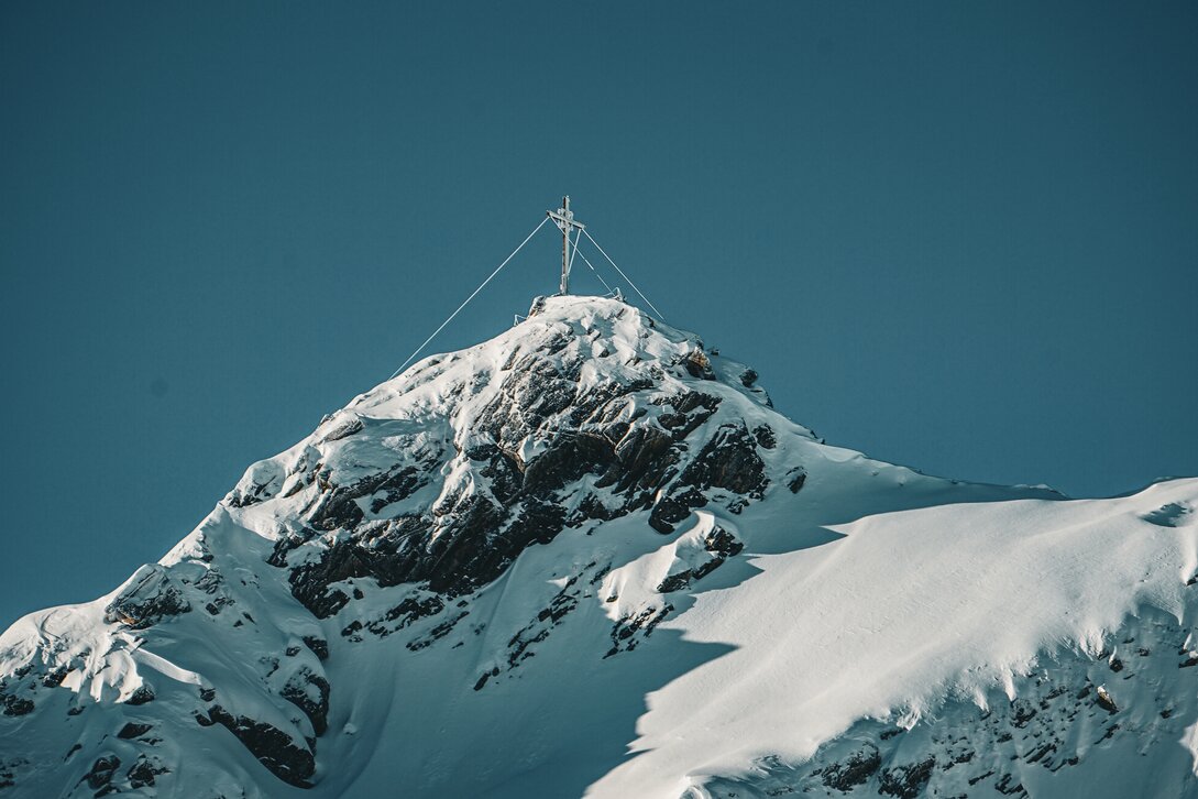 Das verschneite Gipfelkreuz der Zamangspitze in der Silvretta Montafon. | © Silvretta Montafon - Vanessa Strauch