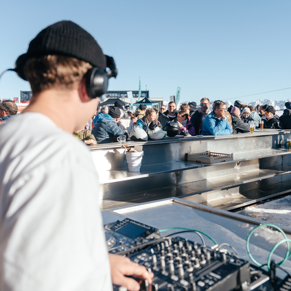 Ein DJ spielt in der Bella Nova währenddessen die Skifahrer ein Getränk genießen | © Silvretta Montafon - Marie Schilcher