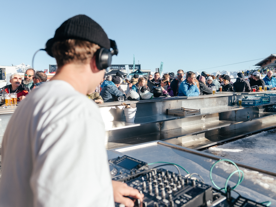 Ein DJ spielt in der Bella Nova währenddessen die Skifahrer ein Getränk genießen | © Silvretta Montafon - Marie Schilcher