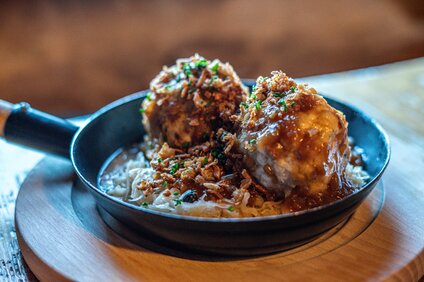 Eine Pfanne mit zwei Semmelknödeln und Sauerkraut im Valisera Hüsli in der Silvretta Montafon. | © Silvretta Montafon - Vanessa Strauch
