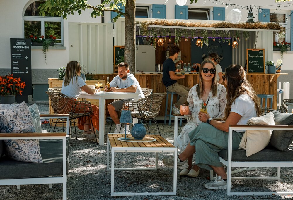 Menschen genießen ihre kühlen Cocktails im St. Josefs Cocktailgarten im Sommer | © Silvretta Montafon - Vanessa Strauch