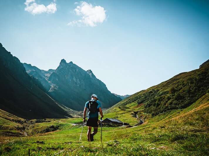 Mann läuft über grüne Wiese beim Montafon Totale Trail in der Silvretta Montafon | © Silvretta Montafon - Jörn Perschbacher