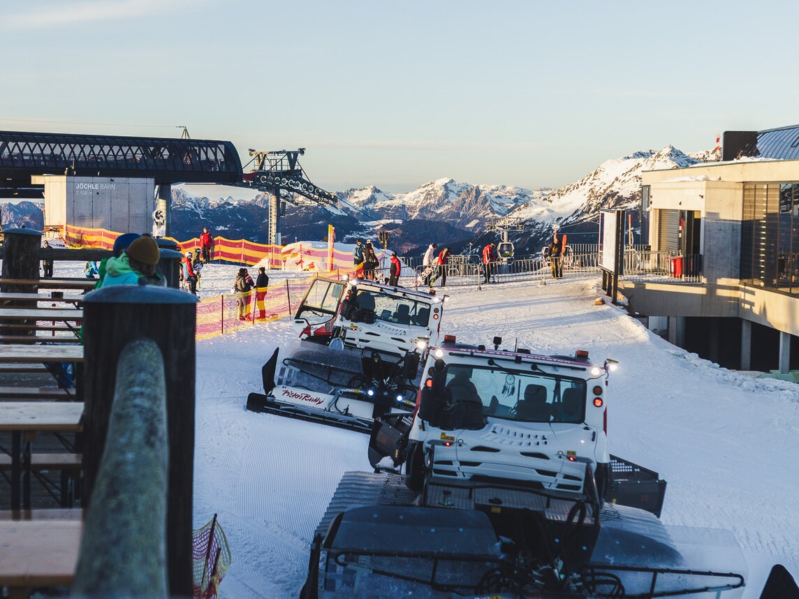 Eine Reihe von Pistenbullys stehen auf der Piste in der Nähe der Bergstation. | © Silvretta Montafon - Roadtyping