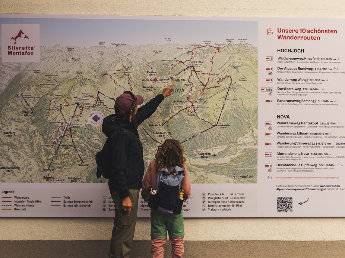Wandern in der Silvretta Montafon | © Silvretta Montafon - Roadtyping Eine Frau und ein Kind stehen vor der Wanderkarte in der Silvretta Montafon. | © Silvretta Montafon - Roadtyping