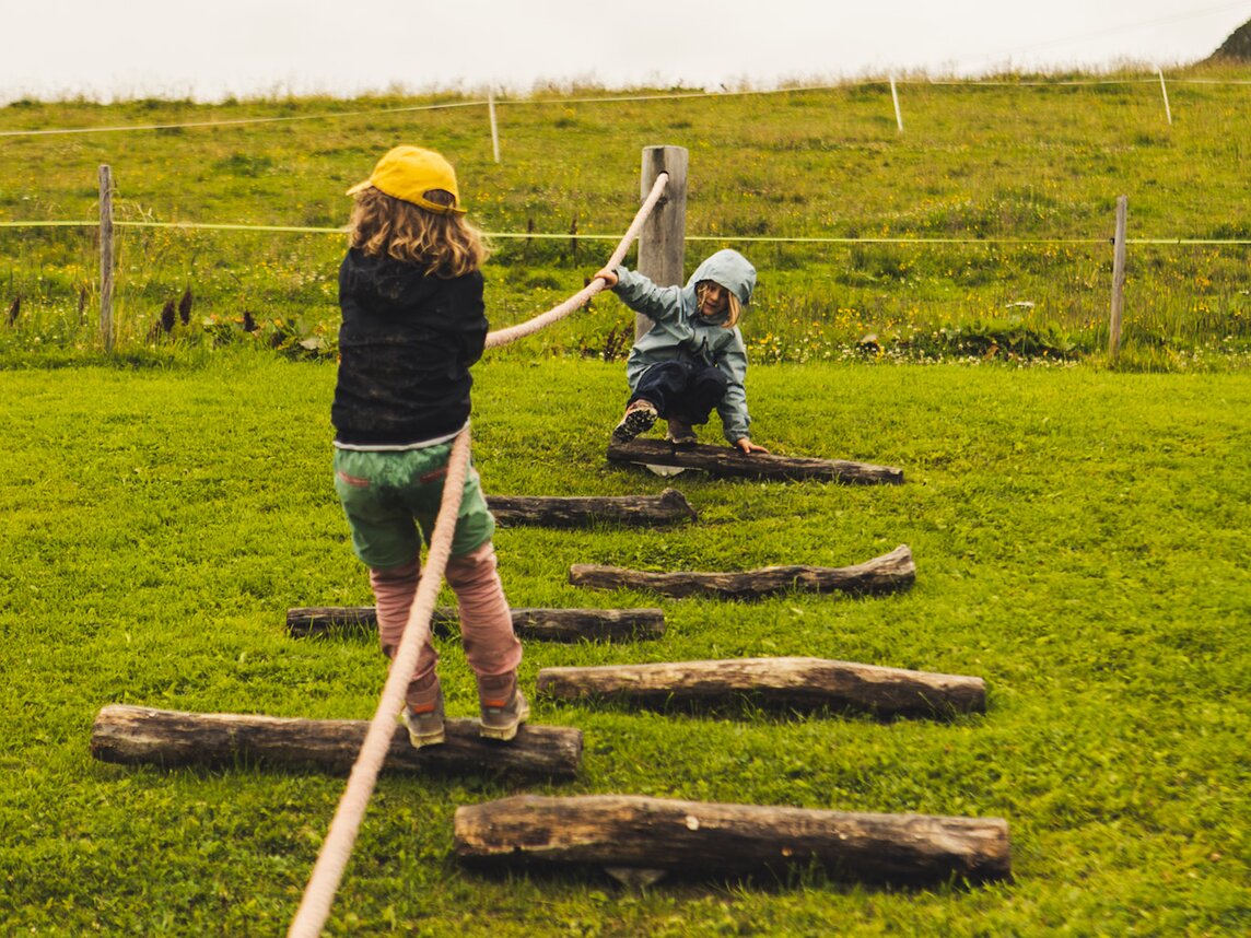 Parcour am Hochjoch - Silvretta Montafon | © Silvretta Montafon - Roadtyping Zwei Kinder klettern auf einem Parcour im Regen in den Bergen. | © Silvretta Montafon - Roadtyping