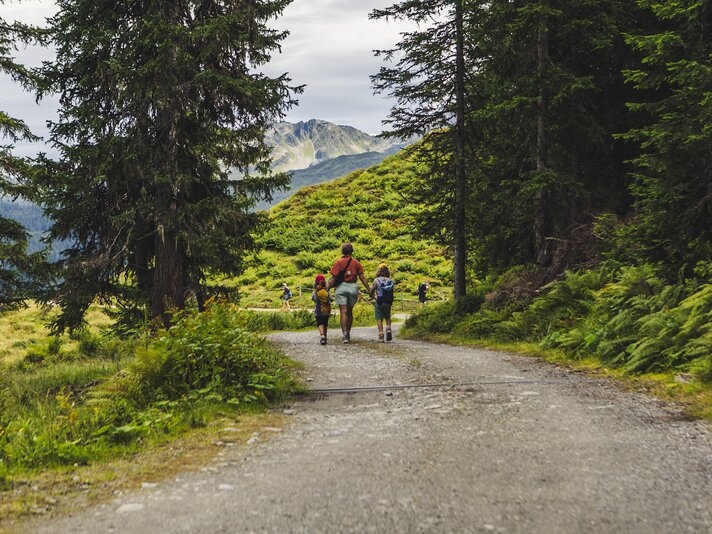 Wandern in der Silvretta Montafon | © Silvretta Montafon - Roadtyping Eine Frau und zwei Kinder laufen auf einem Wanderweg in den Bergen. | © Silvretta Montafon - Roadtyping