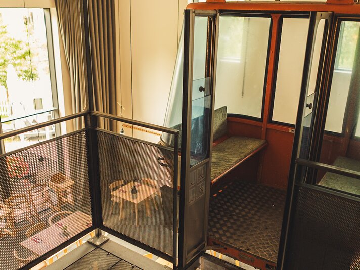 Josefsheim Restaurant & Hostel | © Silvretta Montafon - Roadtyping Der Blick von oben in ein Restaurant mit alter Gondel und moderner Inneneinrichtung. | © Silvretta Montafon - Roadtyping