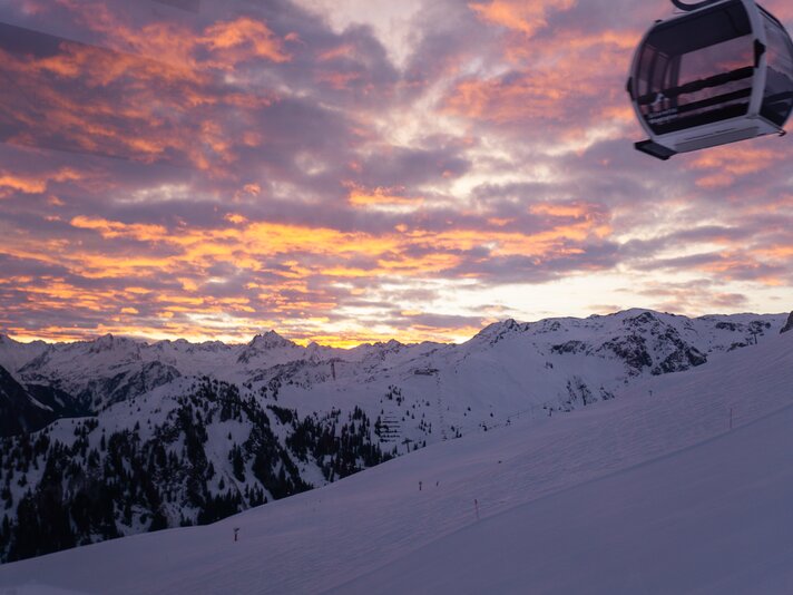 Eine Gondel mit rot gefärbtem Himmel bei einer Sonnenaufgangsfahrt. | © Silvretta Montafon - Lisa von Abenteuermomente