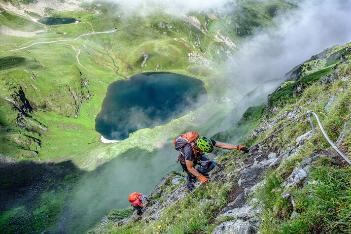 Zwei Personen im Klettersteig oberhalb eines Bergsees in der Silvretta Montafon. | © Silvretta Montafon - Bertram Waldner