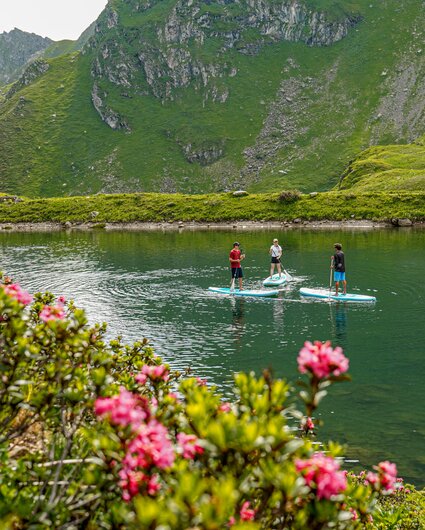 Drei Personen mit SUP paddeln auf einem Bergsee im Seetal am Hochjoch in der Silvretta Montafon. | © Silvretta Montafon - Vanessa Strauch