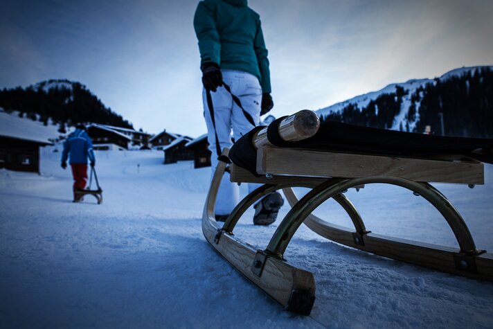 Eine Frau zieht ihren Rodel über den Schnee zur Abfahrt der Nachtrodelbahn Garfrescha in der Silvretta Montafon | © Silvretta Montafon - Daniel Zangerl