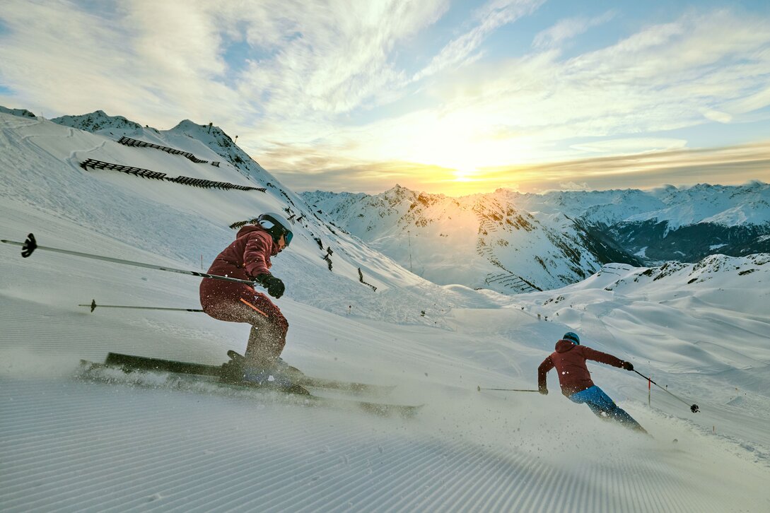 Zwei Skifahrer fahren über die frisch präparierte Piste bei Sonnenaufgang bei der HochjochTotale in der Silvretta Montafon | ©  Silvretta Montafon - Stefan Kothner