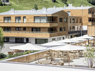 Die Chalets und die Terrasse des Sporthotels Silvretta Montafons im Sommer von Außen