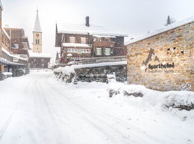 Die Aussenansicht des Sporthotel Silvretta Montafon mit Logo in Gaschurn im Winter.