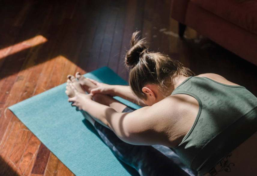 Eine Frau macht eine Yoga-Übung auf einer Matte | © Tina Fehrenbach - Silvretta Montafon