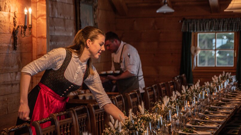 Eine Frau bereitet den Tisch für die Hochzeit in der Alpe Bova vom Sporthotel Silvretta Montafon vor | © Silvretta Montafon - Mara Baues
