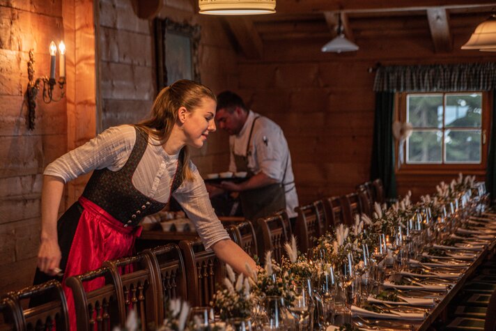 Eine Frau bereitet den Tisch für die Hochzeit in der Alpe Bova vom Sporthotel Silvretta Montafon vor | © Silvretta Montafon - Mara Baues