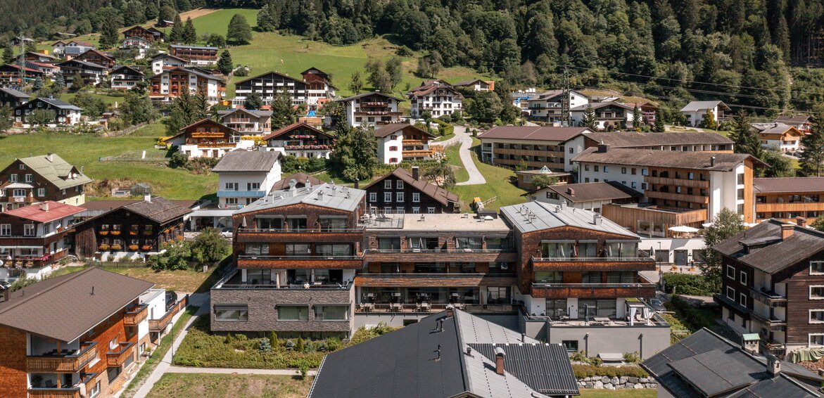 Das Sporthotel Silvretta Montafon im Zentrum von Gaschurn mit traumhafter Berglandschaft im Hintergrund | © Silvretta Montafon - blateral