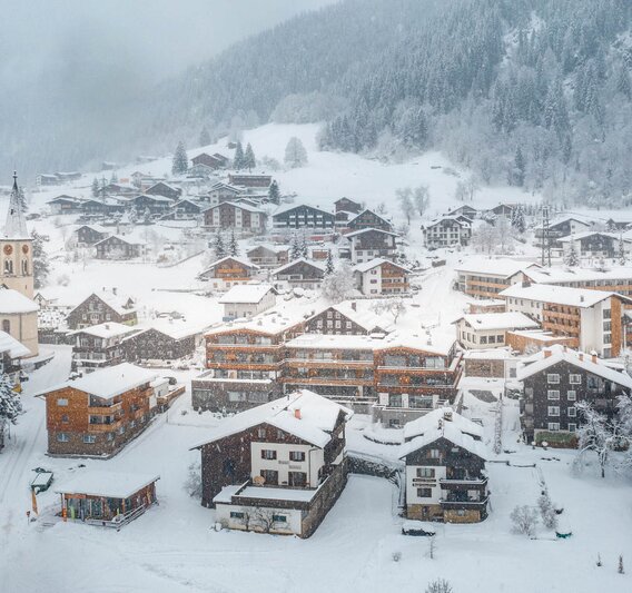 Der Ortskern Gaschurn mit dem Sporthotel Silvretta Montafon währenddessen es schneit  | ©  Silvretta Montafon - blateral