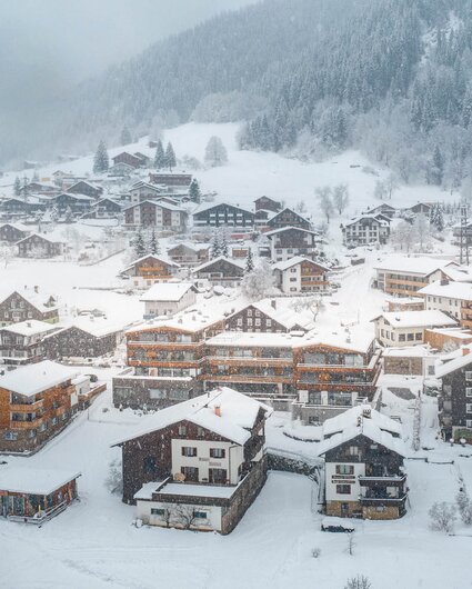 Der Ortskern Gaschurn mit dem Sporthotel Silvretta Montafon währenddessen es schneit  | ©  Silvretta Montafon - blateral