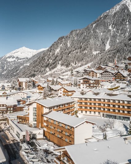 Das Sporthotel Silvretta Montafon schneebedeckt im Vordergrund mit weißen Bergen im Hintergrund | © Silvretta Montafon - blateral