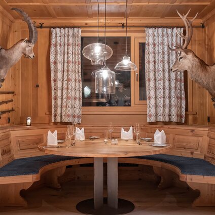 Eine urige Sitzecke mit zwei Hirschgeweihen in der Jägerstube im Sporthotel Silvretta Montafon | © Silvretta Montafon - blateral