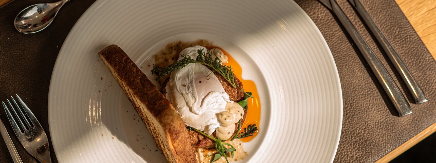 Ein weißer Teller mit einem schön angerichtetem Fischgericht im Sporthotel Silvretta Montafon. | © Silvretta Montafon - Mara Baues