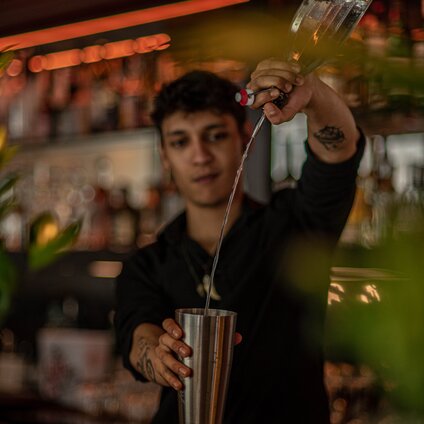 Barkeeper mixt drink pourt alkohol in den cocktail | © Silvretta Montafon - Mara Baues