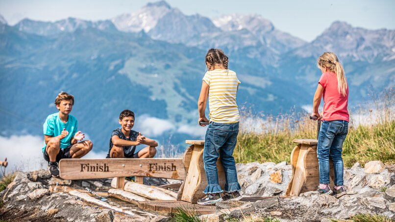 Vier Kinder an den Wellenpumpen am Naturkräftepfad am Erlebnisberg Hochjoch in der Silvretta Montafon. | © Silvretta Montafon - Stefan Kothner
