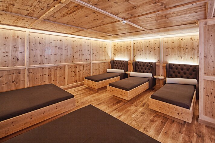Warm beleuchteter Raum mit mehreren Betten aus Zirbenholz | © Silvretta Montafon - Markus Gmeiner