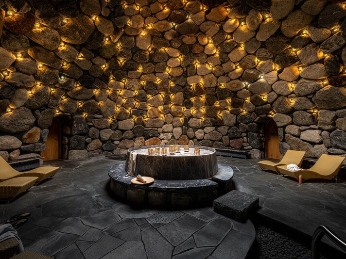 Gold Spa im Sporthotel Silvretta Montafon | © Silvretta Montafon - blateral Das Tepidarium mit goldenem Licht an den Steinwänden und gemütlichen Liegen rundum | © Silvretta Montafon - blateral