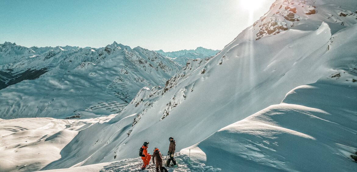 Freerider am Grat - Silvretta Montafon | © Silvretta Montafon - Vanessa Strauch Drei Freerider stehen am Grat vor der Einfahrt in den Tiefschnee in der Silvretta Montafon. | © Silvretta Montafon - Vanessa Strauch