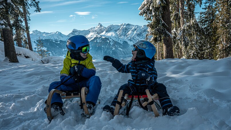 Zwei Kinder haben Spaß auf dem Rodel bei der Naturrodelbahn Kapell in der Silvretta Montafon | © Silvretta Montafon - Vanessa Strauch