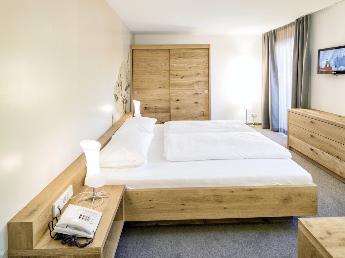 Seitenansicht von der Familiensuite mit Blick auf einen Fernseher | © Silvretta Montafon - Markus Gmeiner