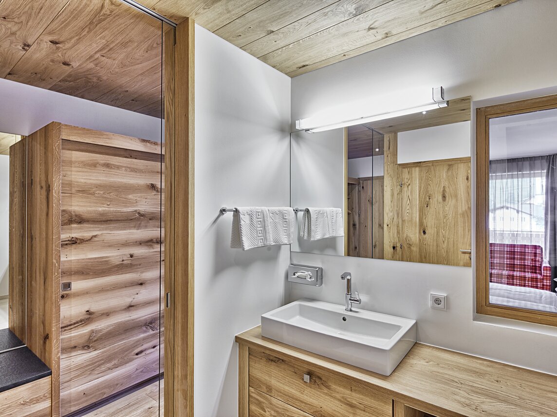 Modernes Waschbecken mit großem Spiegel im Sporthotel Silvretta Montafon | © Silvretta Montafon - Markus Gmeiner